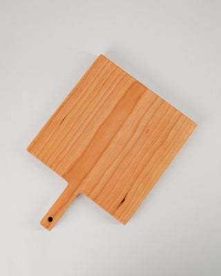 Wooden cutting board with a handle on a light gray background