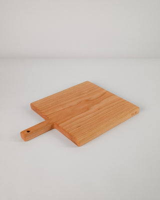 Wooden paddle with handle on a light gray background