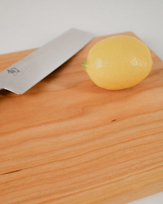 Knife and lemon on a wooden cutting board