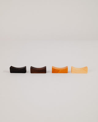 Four chopstick rests side by side showing Indian laurel, walnut, cherry and maple wood tones
