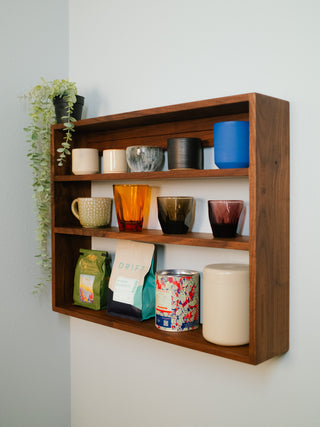 Monolith Wall Shelf styled with coffee mugs and small ceramics across three solid hardwood tiers